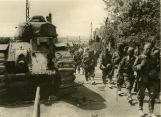 Colonne de militaires allemands passant près du char B1 bis « Glorieux » du 8e bataillon de chars de combats (BCC), détruit à Moÿ-de-l’Aisne le 17 mai 1940 ©Arch. dép. de l’Aisne, 2 Fi 479