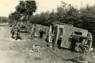 Motocycliste allemand à côté d'un convoi d'artillerie de canons de 75 mm abandonné à la sortie Est de La Capelle ©Arch. dép. de l'Aisne 2 Fi 338
