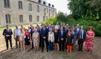 Photo de groupe des 42 conseillers départementaux de l’Aisne réunis devant un bâtiment en pierre, le 16 juillet 2026