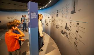 Visiteurs découvrant la chronologie de la Seconde Guerre mondiale dans le parcours de l’exposition permanente du Musée de la Résistance et de la Déportation de l’Aisne